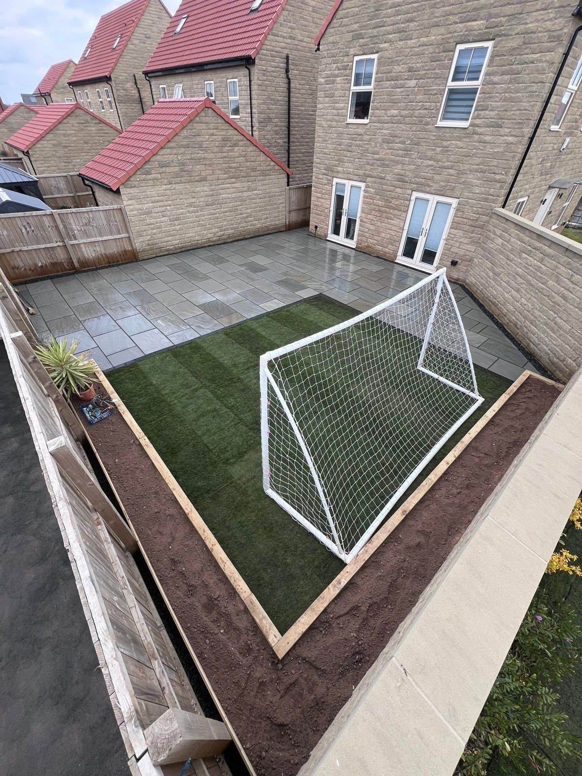 New turf with sleeper borders and a patio, goal back in place