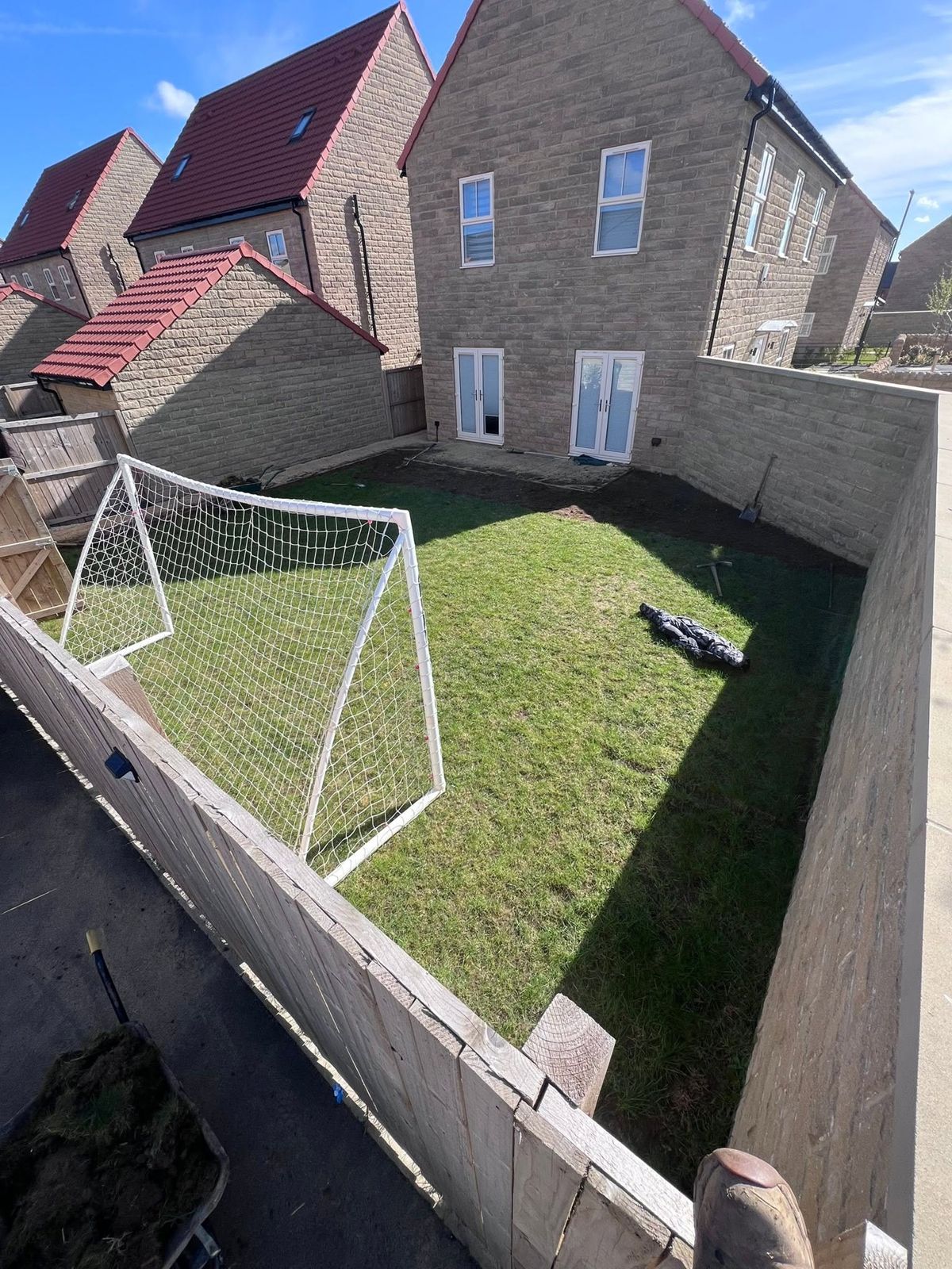 Patchy lawn with a football goal