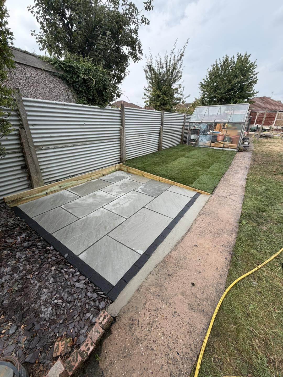 New grey patio and fresh turf beside the same path