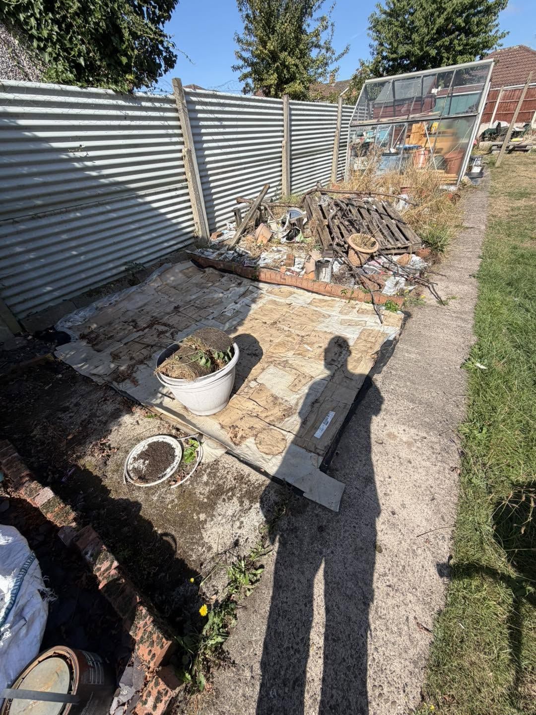 Rubble and broken paving beside a garden path